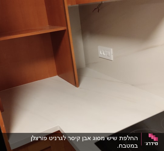 משטח שיש לבן במטבח עם כיריים חשמליות